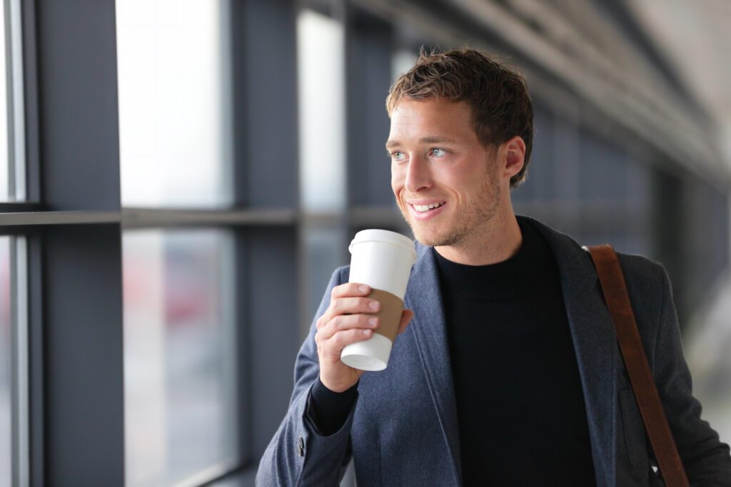 Businessman,Drinking,Coffee,Walking,In,Airport.,Casual,Urban,Professional,Smiling